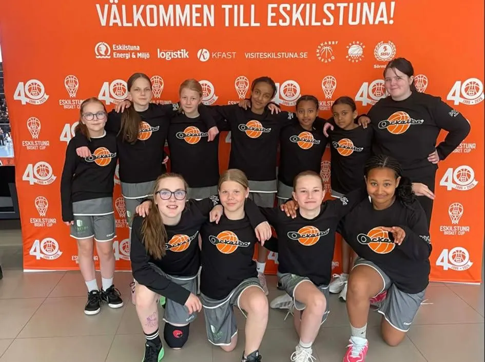 Flickor i klubbens svarta tröjor med Ockelbobollen